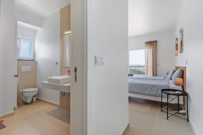 Un dormitorio moderno con cama, mesita de noche y vistas al exterior.