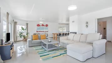 Ein modernes Wohnzimmer mit einer Couch, einem Couchtisch und einem Fernseher.