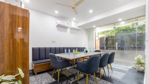 Un salón de conferencias con una larga mesa, sillas, un sofá y un ventilador de techo.