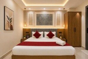 Una camera d'hotel moderna con un letto grande, una testiera in legno e una parete decorata di rosso.