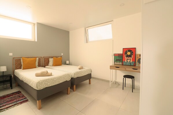 Een slaapkamer met twee bedden, een bureau en een stoel.