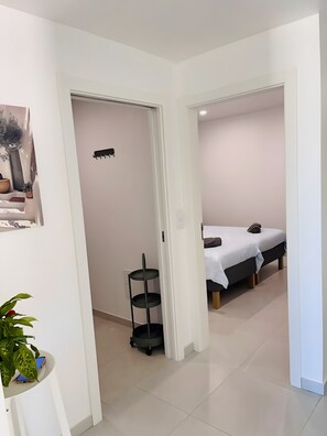 Habitación de hotel moderna con cama, mesita de noche y una planta pequeña.