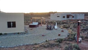 A desert-style building with a patio area featuring outdoor furniture and a hot tub. - 3-bedroom house in El Prado, includes 2 bedroom casita on property. (El Prado)