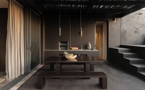 A modern interior with a dark-toned dining table, a bowl of fruit, and a minimalist design. - La Reserva Tulum (Tulum)