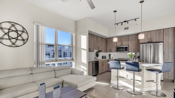 Un apartament modern amb zona de seure, cuina i menjador.