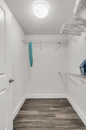 A laundry room with a white door, a ceiling light, a drying rack, and a blue towel. - Blu Apartments (Miami)