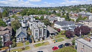 A residential area with modern houses, a street, and a clear blue sky. - Ballard Rooftop • 3BR Modern Townhome (Seattle)