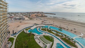 Un complexe hôtelier doté d’une grande piscine, d’une plage et offrant une vue sur l’océan.