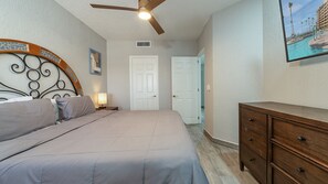 A bedroom with a bed, a dresser, a ceiling fan, and a door. - Beautiful Ocean View Retreat With Panoramic Ocean Views (Puerto Peñasco)