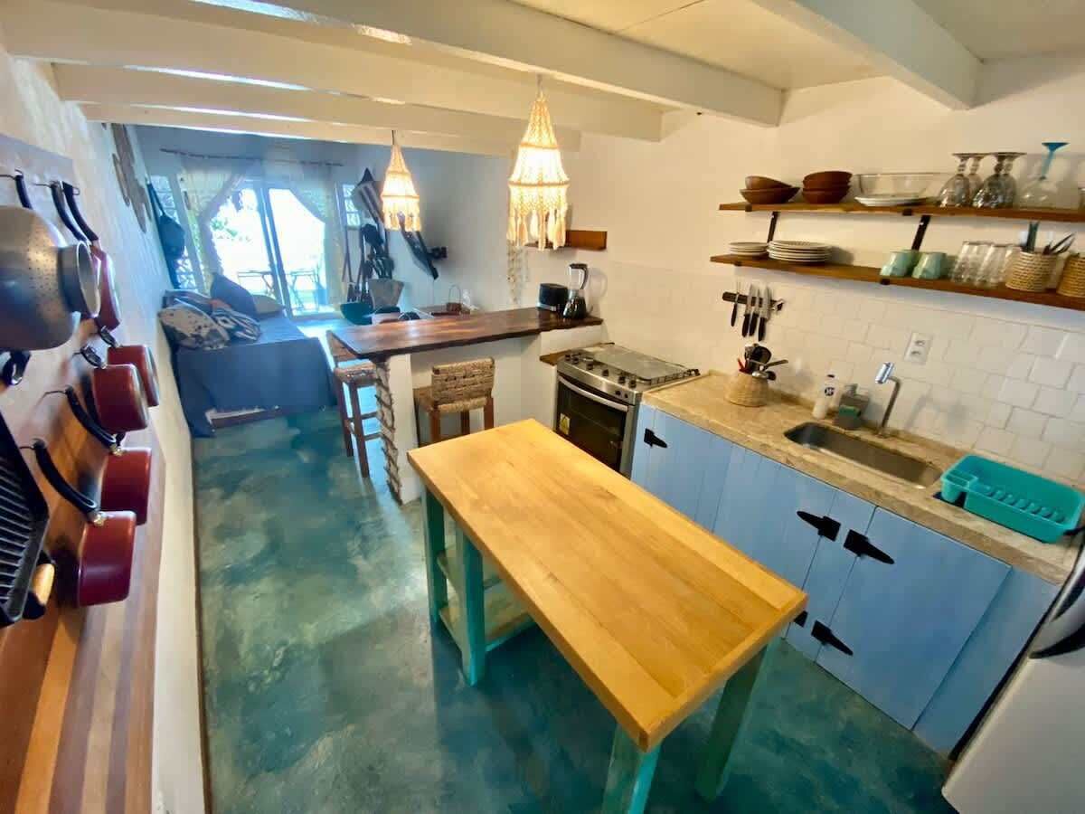A kitchen with a wooden table, a stove, and a sink.