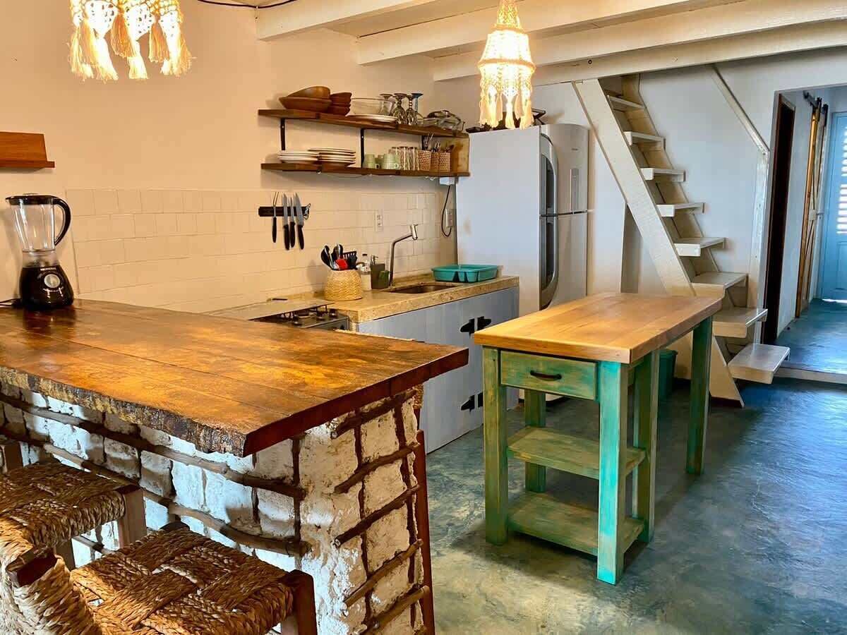 A kitchen with a bar area, a staircase, and a dining table.