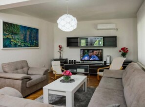 A living room with a sofa, chairs, a coffee table, a TV, and artwork on the wall. - Villa Ante With Outdoor Pool (Imotski)