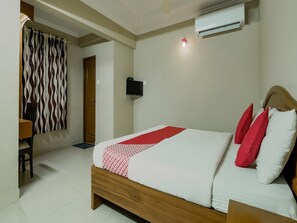 A bedroom with a bed, a TV, an air conditioner, and a door. - Collection O Kadavanthra (Kanayannur)