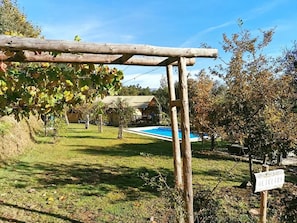 Eine Holz-Pergola, ein Schwimmbecken und ein Schild mit der Aufschrift 'OLIVEIRA'.