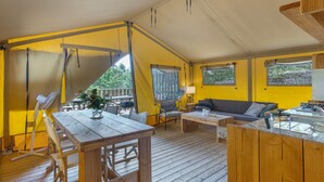 A tented accommodation with a wooden deck, a dining table, a sofa, and a kitchen area. - "Pinheiro Glamping" Tent with Mountain View, Private Pool and Wi-Fi (Arco de Baúlhe)
