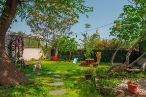 Ein Garten mit Picknicktisch, Rutsche und Baum.
