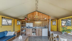 A compact kitchen with wooden cabinets, a central island, and a dining area with chairs.