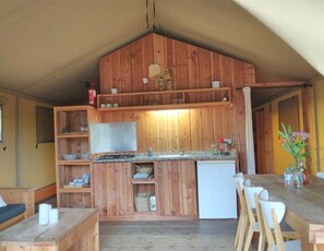 Un intérieur en bois comprenant un coin cuisine, une table à manger avec des chaises et un canapé.