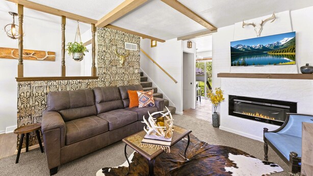 A modern living room with a fireplace, a sofa, a coffee table, and a staircase. - Santa Fe 1976! Work Travel Stay Awhile Game Room! (Ottawa)
