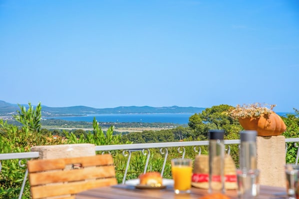 Une table dressée avec des aliments pour le petit-déjeuner, donnant sur la mer.