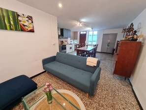 Un salon avec un canapé, une table à manger et une cuisine en arriÚre-plan.