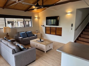 A modern living room with a sofa, coffee table, and TV.