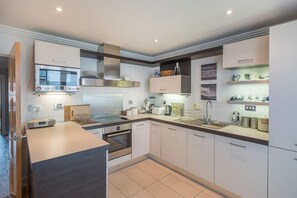 Una cucina moderna con forno integrato, microonde e cappa aspirante in acciaio inossidabile.