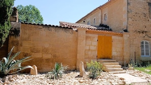 A stone building with a tiled roof, a wooden door, and a small staircase leading to the entrance. - Mas de l'Amarine Between Camargue and Provence (Bellegarde)