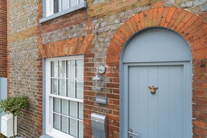 A brick building with a blue door, a window, and a mailbox. - Abaca House with 3 bedrooms and 2.5 bathrooms (Cowes)