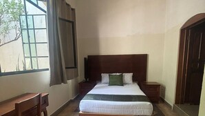 A bedroom with a bed, bedside tables, a desk, and a chair. - HOTEL SAN JOSE CENTRO HISTORICO (San Luis Potosí)