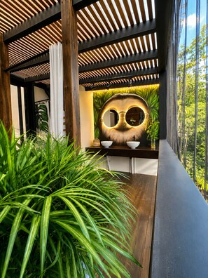 Un intérieur moderne avec un plafond en bois, un grand miroir mural et une table en bois sur laquelle sont posés des bols.