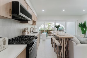 Una cocina moderna con estufa a gas, microondas y armarios de madera.