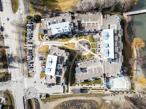 An aerial view of a complex with multiple buildings, parking areas, and a central courtyard.