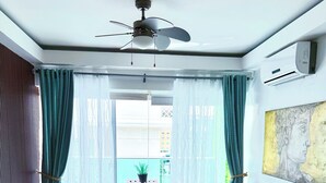 Un saló modern amb un sofà, una taula de centre i un ventilador de sostre.