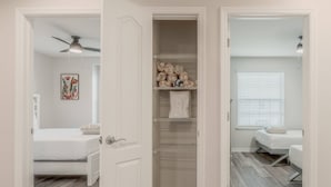 A bedroom with a bed, a closet with shelves, a ceiling fan, and a window with blinds. - 5BR Solterra Home Near Disney With Pool (Davenport)