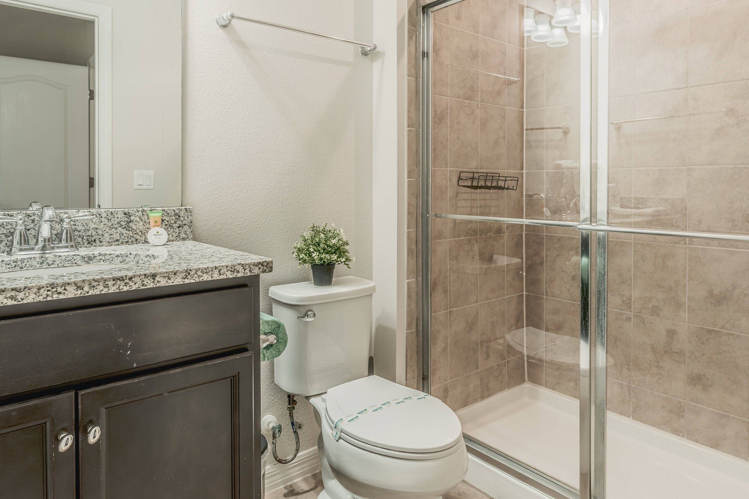 Un baño con inodoro, lavamanos y zona de ducha.