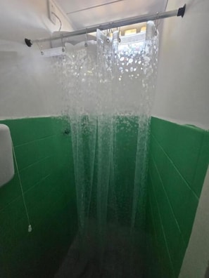 A shower with water running, green walls, and a window above. - Pousada Hostel Beach Pajuçara (Maceió)