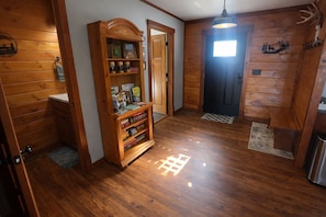 A wooden interior with a hallway, a door with a window, and a shelf with various items. - Observation Deck, Breath Taking Grand Canyon Views (Jasper)