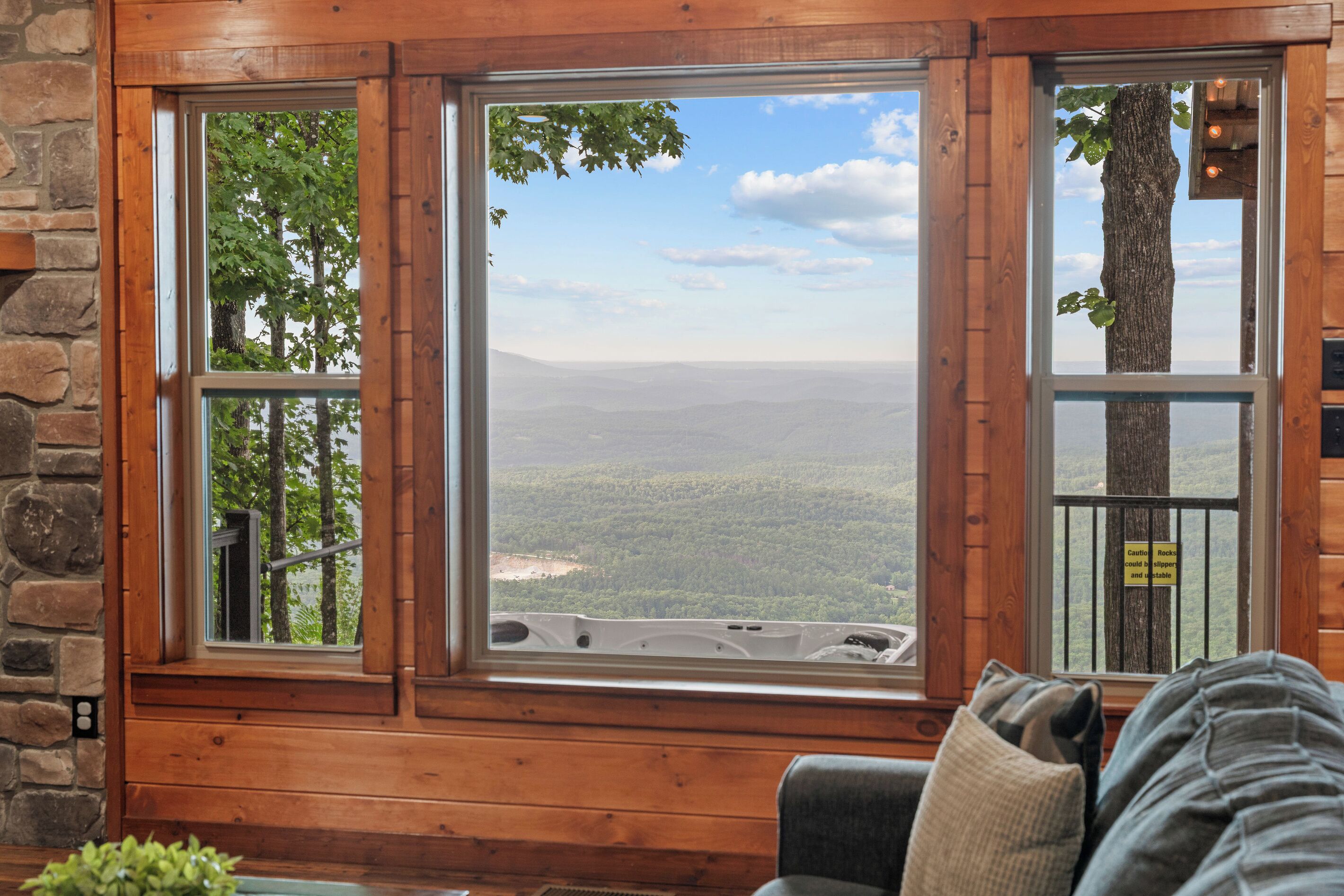 Ein Zimmer mit großem Fenster und Blick auf eine bewaldete Landschaft.