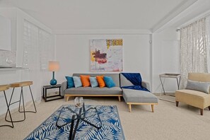 Ein Wohnzimmer mit einer Couch, einem Couchtisch, einem Beistelltisch und einem Sessel.