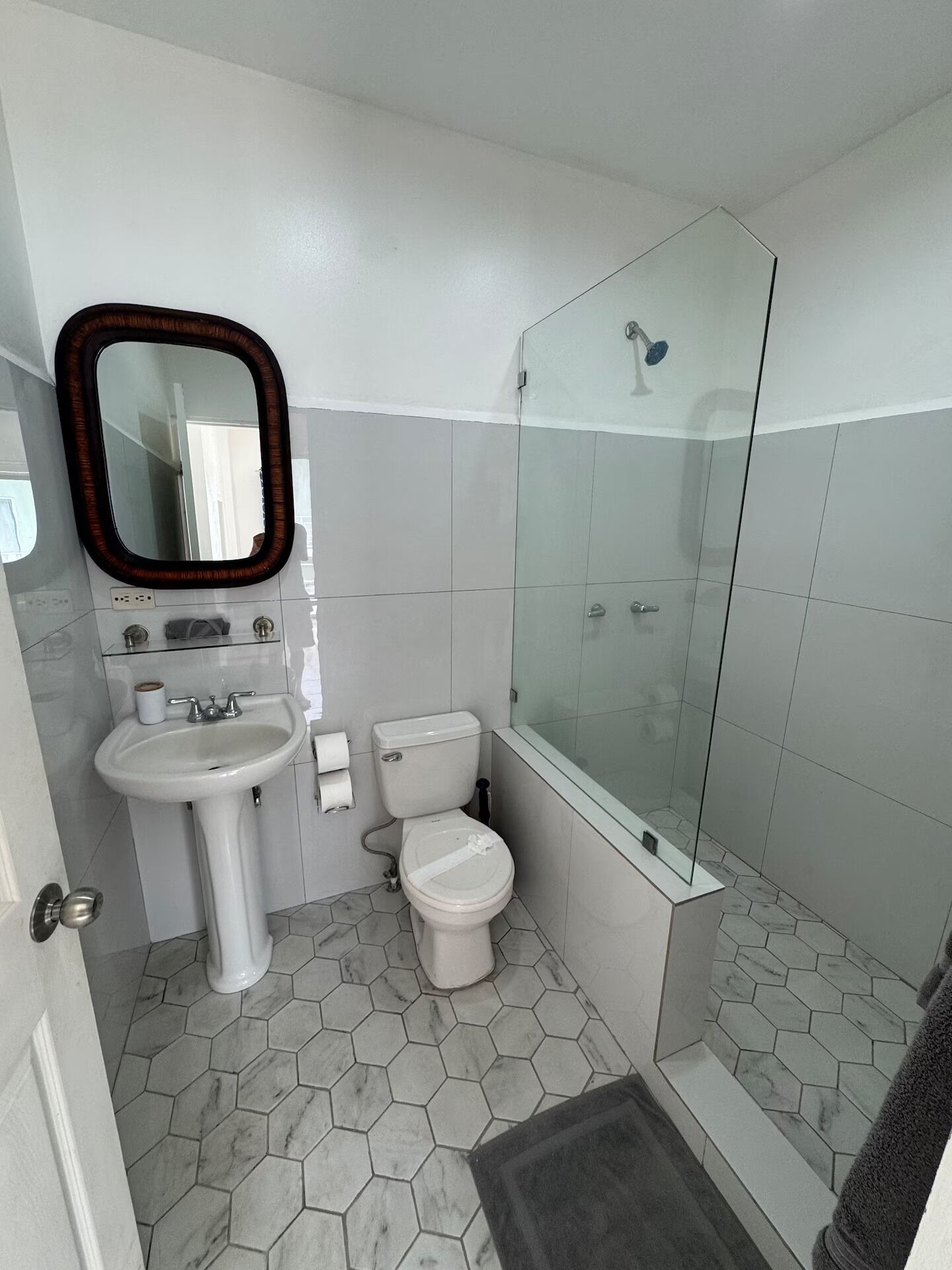 A bathroom with a sink, toilet, and glass-enclosed shower.