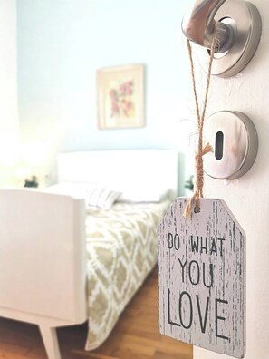 Ein Schlafzimmer mit Bett, einer Tür inklusive Türgriff und einem motivierenden Spruch.