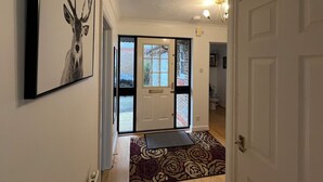 Ein Flur mit einer Tür, einem Teppich mit Muster und einem gerahmten Bild an der Wand.