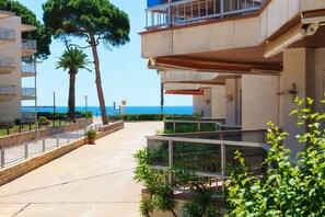 A coastal hotel with balconies, a paved walkway, and a view of the sea. - Beachfront apartment in Vilafortuny (Cambrils)