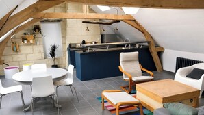Loft moderno con cucina, zona pranzo e angolo salotto.