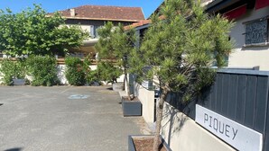 A parking area with a sign reading 'PTOULEY' and a building with a sign 'LES STUDIOS DU CENTRE'. - Les Studios du Centre Buch (La Teste)