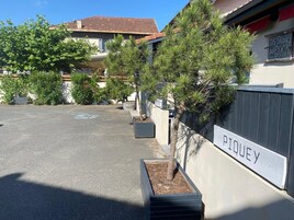 Un área de estacionamiento con un letrero que dice 'PTOULEY' y un edificio con un letrero que dice 'LES STUDIOS DU CENTRE'.