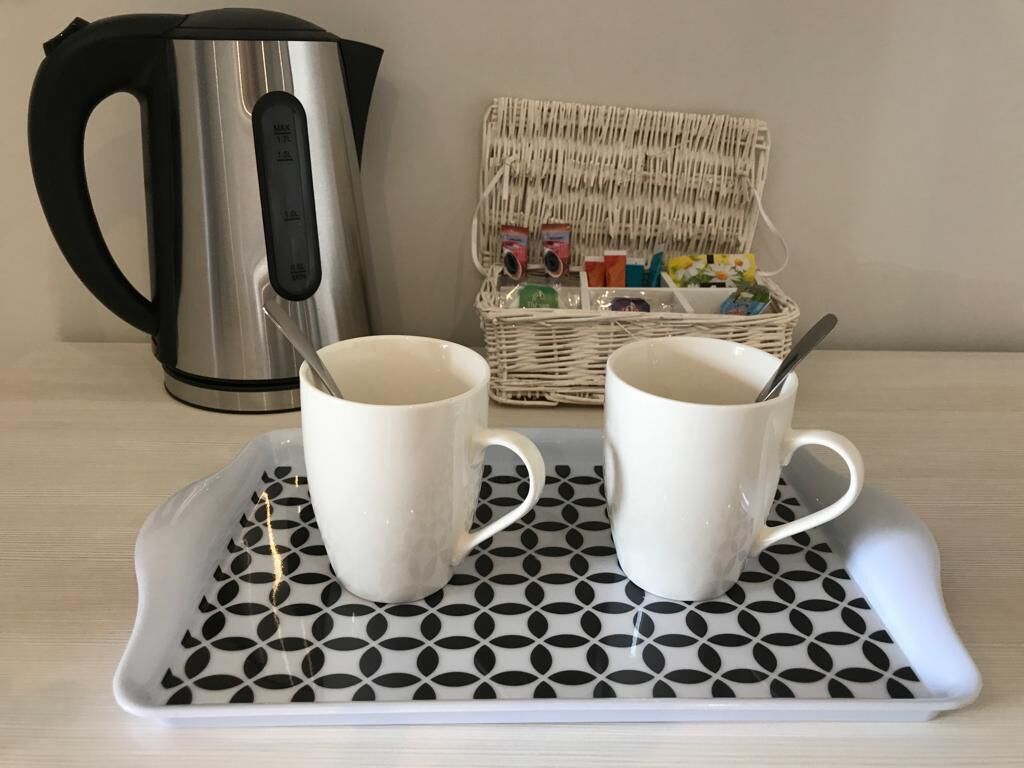 Un plateau avec deux tasses blanches et un autre plateau aux motifs noirs et blancs.