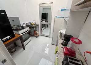 A compact kitchen with a stove, sink, and refrigerator.