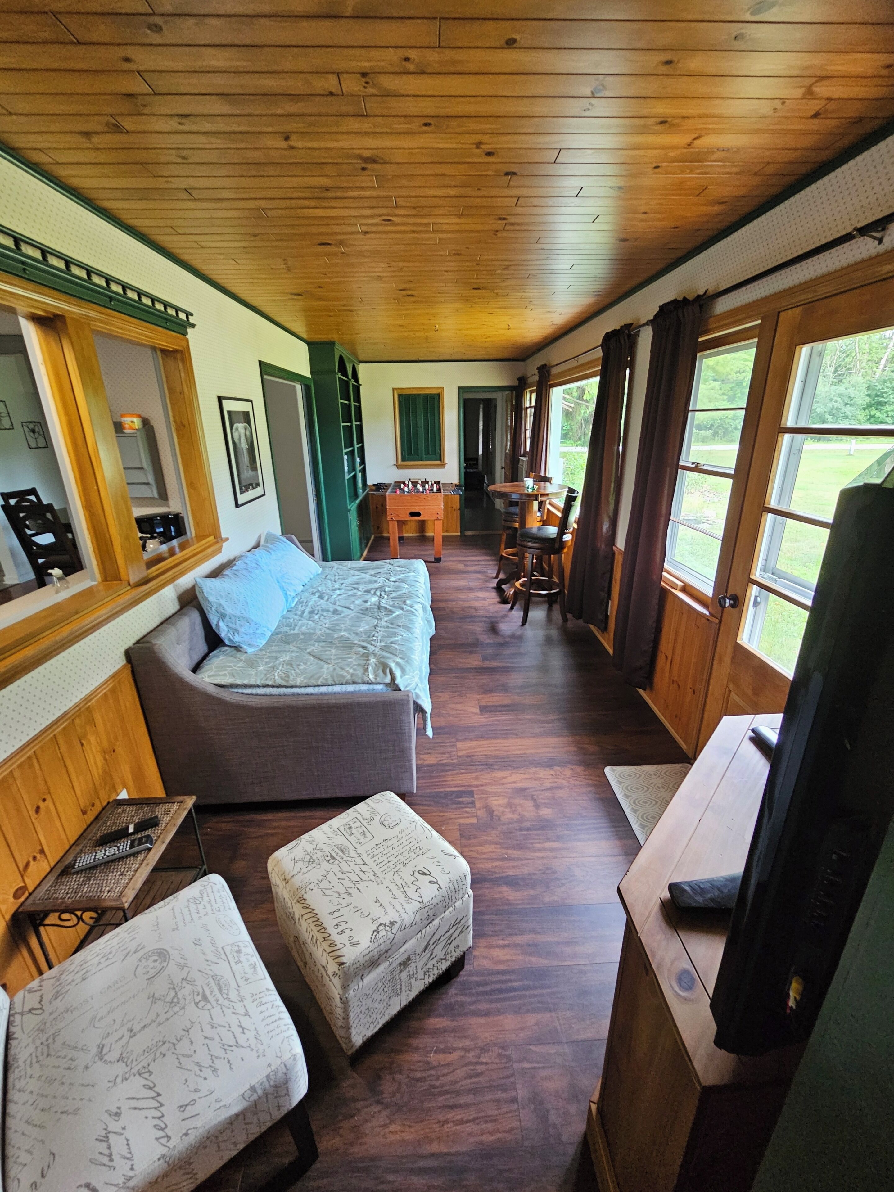 Una habitación con cama, sofá, mesa y televisor.